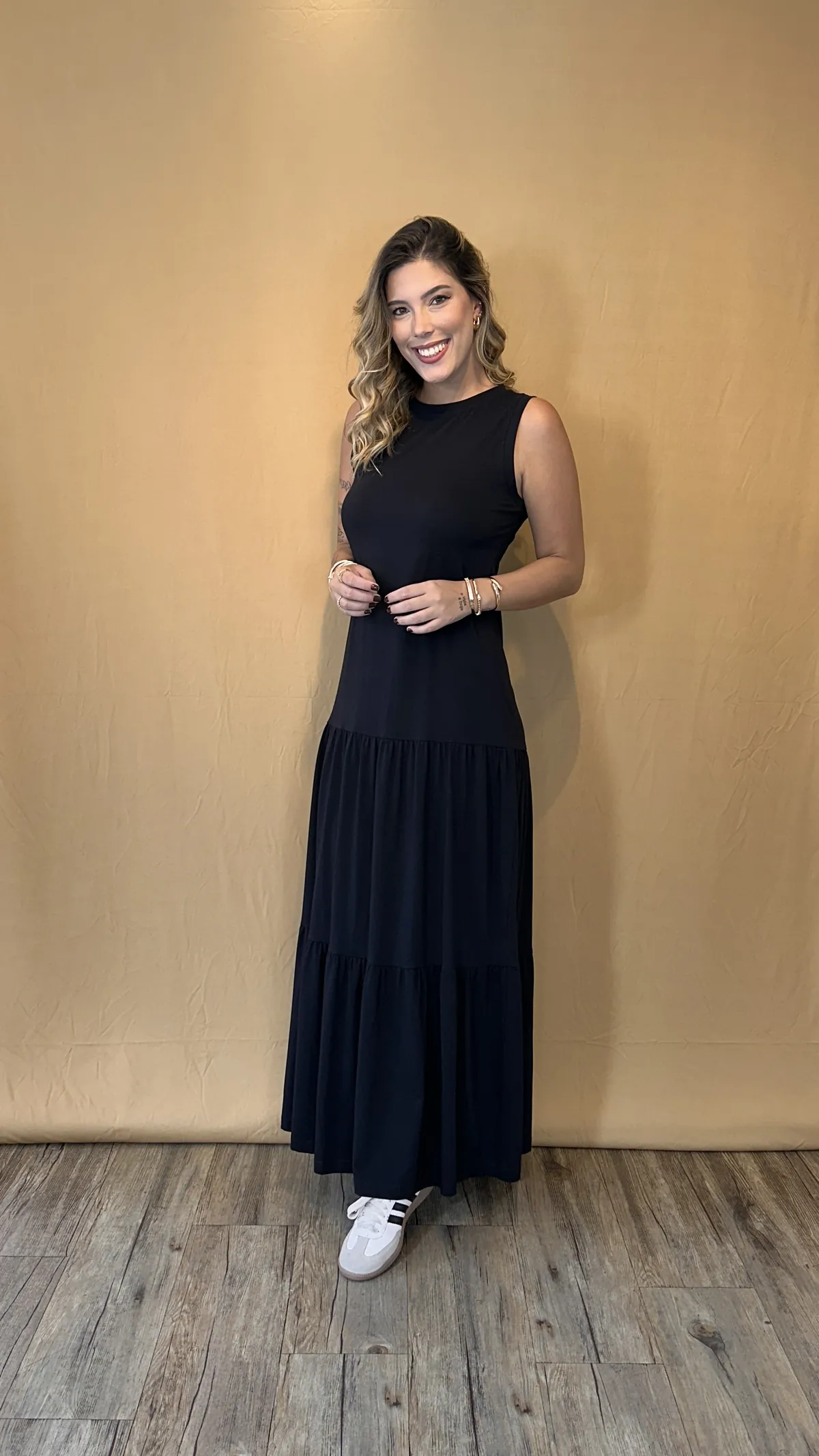 Vestido longo preto, sem manga, com saia em camadas