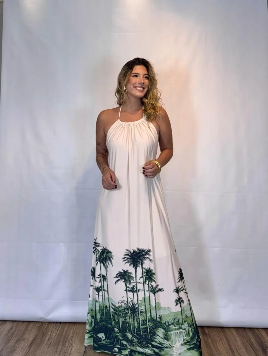 Vestido longo branco de alças amarradas, com barra de palmeiras
